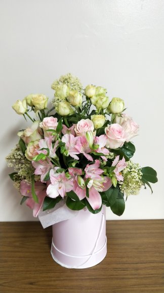 Stunning array of pastel flowers presented in a soft pink hat box.